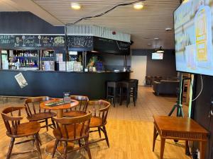 a restaurant with tables and chairs and a bar at Hotelli Patruuna in Imatra