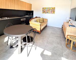 a kitchen and living room with a table and a couch at Korora's Haven Coffs Harbour in Kororo Basin