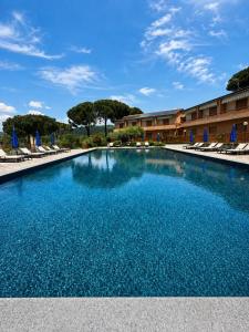 a large swimming pool with chairs and a hotel at Hotel Ristorante Il Gabbiano in Passignano sul Trasimeno