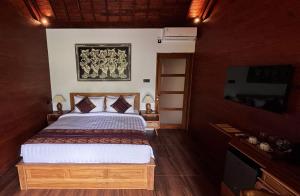 a bedroom with a bed and a tv in it at ChannaS villas in Payangan +20 photos