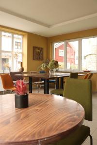 a dining room with tables and chairs and windows at Hostel in Böhlen