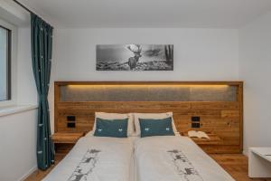 a bed with a wooden headboard in a bedroom at Shasta Mountain Lodge in Cavalese