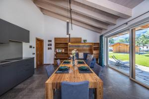 a kitchen and dining room with a wooden table and chairs at Shasta Mountain Lodge in Cavalese