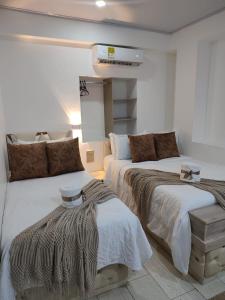 a bedroom with two beds and a air conditioner at Hotel Aquamarina Maicao in Maicao