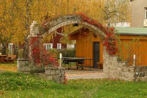 an archway with a picnic table in a yard at Hostel in Böhlen