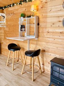 a table and two chairs in a room with wooden walls at Riverside Garden B and B in Bishops Village