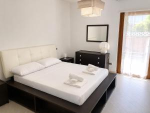 a bedroom with a large white bed with two towels on it at Casa Ulivo in Pulsano