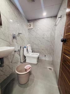 a bathroom with a toilet and a sink at Lowfare Hotels Bengaluru in Bangalore