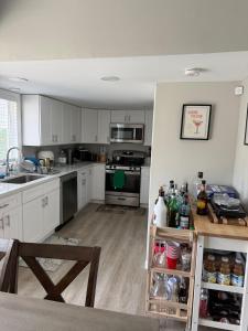 a kitchen with white cabinets and stainless steel appliances at 2 bedroom beachfront fully refurbished home in East Haven