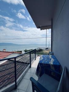 a balcony with a bed and a view of the ocean at Magklaras Seaside Apartments in Néa Palátia
