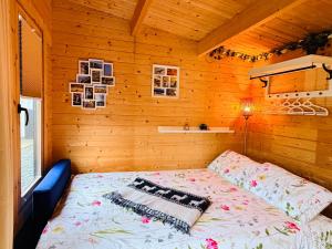 a bedroom with a bed in a wooden cabin at Riverside Garden B and B in Bishops Village