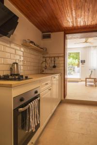 a kitchen with a stove top oven next to a door at Rupica 5 in Stara Novalja