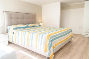 a bedroom with a large bed with a striped blanket at Mediterraneum - Loft in Sannicola