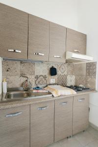 a kitchen with wooden cabinets and a sink at Mediterraneum - Loft in Sannicola