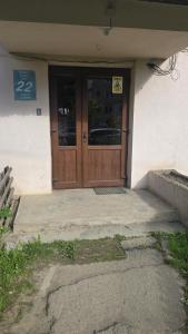 a building with a wooden door with a sign on it at Sissi Apartments in Gheorgheni