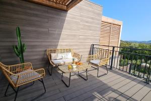 a patio with chairs and a table on a balcony at Luxurious Duplex With Pool Garden Balcony in Lecci