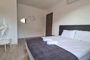 a bedroom with a large white bed and a table at Luxurious Duplex With Pool Garden Balcony in Lecci +18 photos