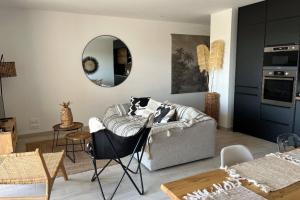 a living room with a couch and a mirror at Luxurious Duplex With Pool Garden Balcony in Lecci
