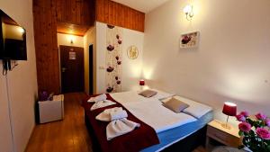 a bedroom with a large bed with towels on it at Penzion Alfa Poděbrady in Poděbrady