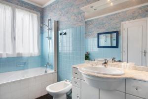 a blue bathroom with a sink and a tub and a toilet at Chambres D'hôtes De Kersehen in Plouider +40 photos