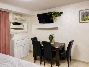 a dining room with a table with chairs and a tv on the wall at Monetegro Seaside in Rafailovici
