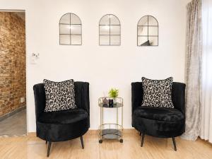 two black chairs and a table in a room at Zhantique Guest House 2- Unit 10 in Boksburg