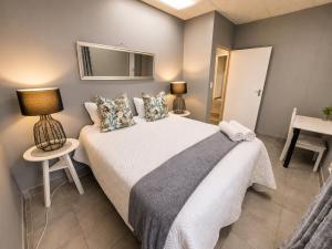 a bedroom with a bed and a table and a mirror at Zhantique Guest House 2- Unit 10 in Boksburg +15 photos