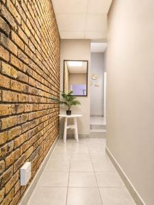 a brick wall in a hallway with a table and a plant at Zhantique Guest House 2- Unit 10 in Boksburg