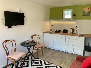 a living room with a table and chairs and a kitchen at Kisbirs Vendégház in Tokaj