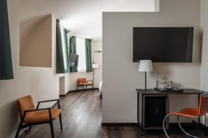 a room with chairs and a tv on a wall at BYPILLOW Grand Central in Padova