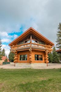 a large log cabin with a large window at Dor De Munte in Mărişel