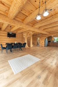 a large room with a wooden ceiling with a table and chairs at Dor De Munte in Mărişel
