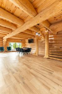 a large room with a wooden ceiling with a table and chairs at Dor De Munte in Mărişel +39 photos