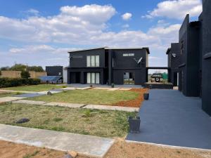 a black house with a yard in front of it at Team Sek Guest Studio in Mahikeng