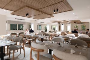 a restaurant with tables and chairs and people in the background at Barceló Cairo Pyramids in Cairo +55 photos