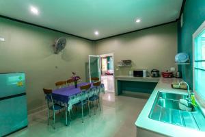 a kitchen with a table with a purple table cloth at Areeya Phubeach Resort Coliving Coworking in Ao Nang Beach
