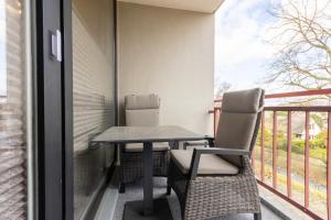 a table and chairs on a balcony with a view at Meerzeit in Steinhude- Exklusives 1 Zimmer Appartement in Wunstorf