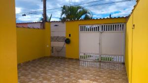 a yellow house with two garage doors at Casa Martinez in Mongaguá