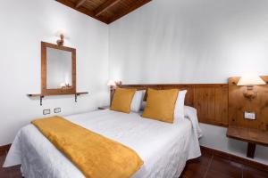 a bedroom with a bed with a yellow blanket on it at Home2Book La Molina B, Cozy Country House in Triquivijate