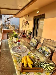 a table with bananas and pineapples on a balcony at Theros Lux Apartment in Émbonas