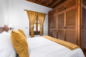 a bedroom with a large white bed with wooden cabinets at Home2Book La Molina B, Cozy Country House in Triquivijate