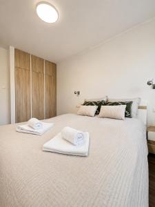 a bedroom with a large white bed with towels on it at Apartament Wisła Centrum in Wisła
