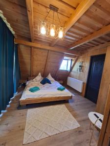 a bedroom with a bed in a wooden house at Cabana 3 Stejari Maramureș in Călineşti +137 photos