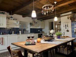 a kitchen with a wooden table with two glasses of wine at Gallery loft Myjava Hrachoviste in Hrachovište