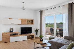 a living room with a couch and a tv at Maslina in Vrsi