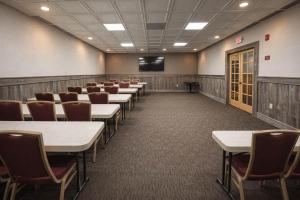 a conference room with tables and chairs and a tv at Motel 6 Rawlins, WY in Rawlins