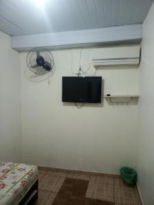 a room with a fan and a tv on a wall at Hotel e Galeria Vizza in Goiânia +12 photos