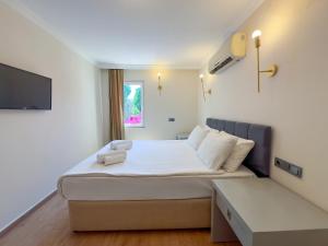 a hotel room with a bed and a tv at Moonshine Hotel Suites in Bodrum City +53 photos