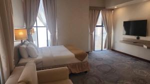 a hotel room with a bed and a couch at Grand Tourist Hotel in Muscat