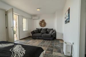 a living room with a couch and a bed in it at Villa Tonic by Mykonos Mood in Agios Ioannis Mykonos